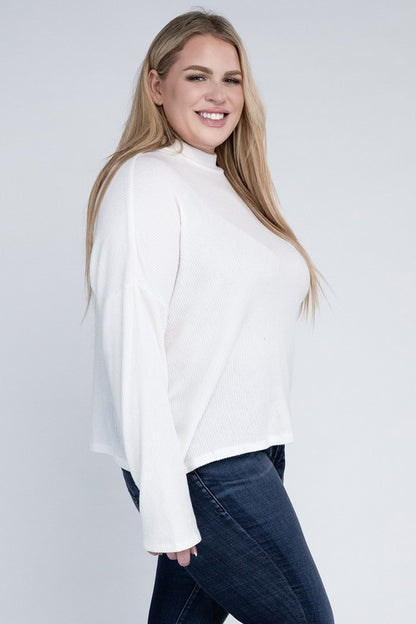 Plus size model wearing Raya Curvy Plus Drop Shoulder Top in off white with mock neck, side view.
