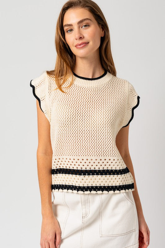 A chic white sweater top with cap ruffle sleeves and bold black color-contrast trim, featuring a round neckline, and playful detailing.