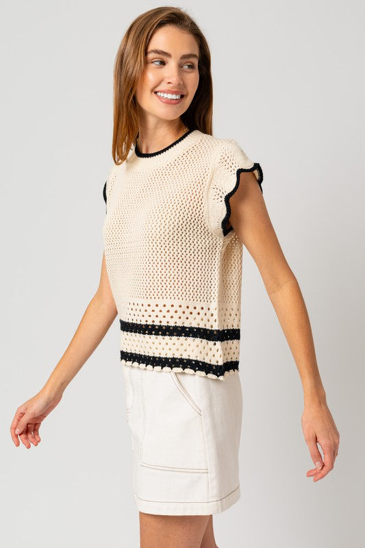 A chic white sweater top with cap ruffle sleeves and bold black color-contrast trim, featuring a round neckline, and playful detailing.