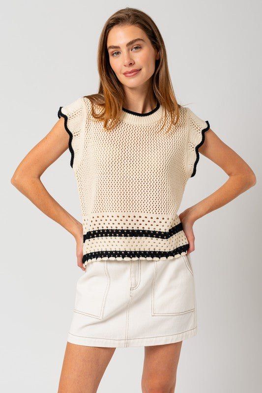 A chic white sweater top with cap ruffle sleeves and bold black color-contrast trim, featuring a round neckline, and playful detailing.