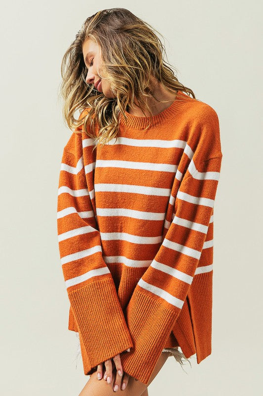 Rust oversized sweater with a ribbed hem and striped pattern, featuring a round neckline and long sleeves.