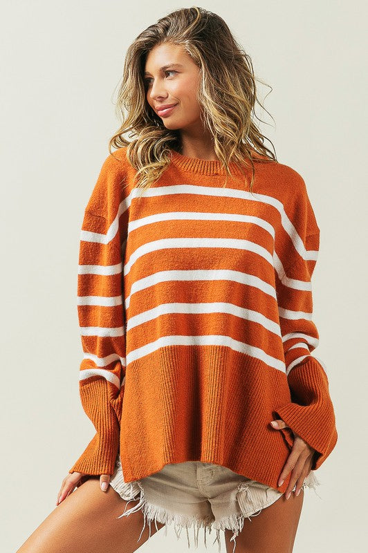 Rust oversized sweater with a ribbed hem and striped pattern, featuring a round neckline and long sleeves.