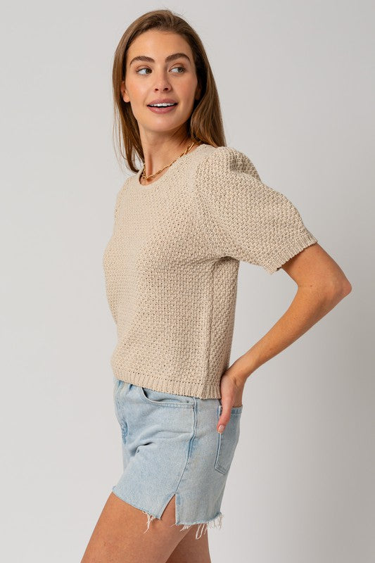 Woman's textured oatmeal sweater with a round neckline and short puff sleeves.