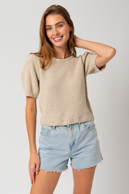 Woman's textured oatmeal sweater with a round neckline and short puff sleeves.