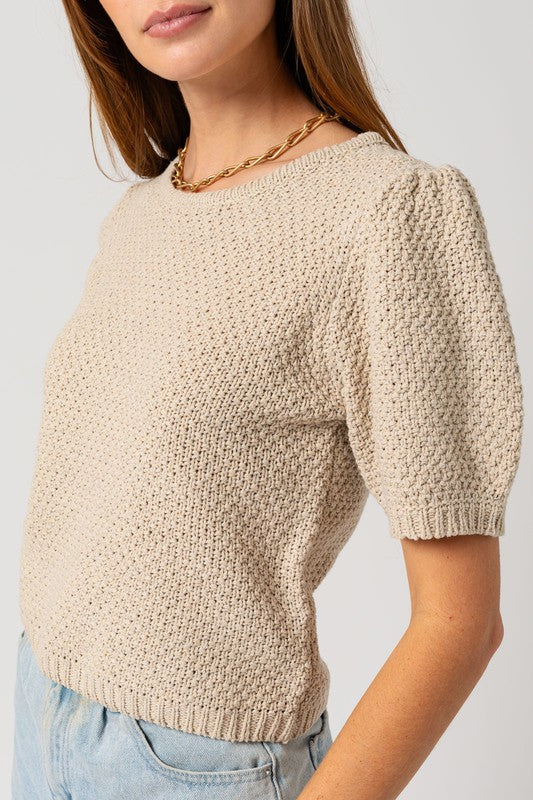 Woman's textured oatmeal sweater with a round neckline and short puff sleeves.