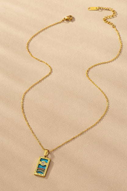 Tarot Card Sun Pendant Necklace with turquoise background and rhinestone rainbow on gold-tone chain.