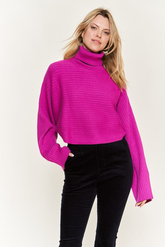 Front view Giada Plus Size Mock Neck Wide Sleeves Sweater in fuchsia styled with black pants.