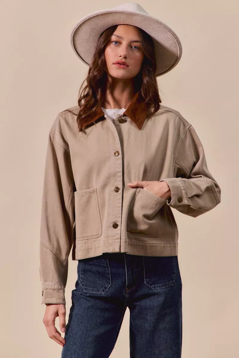Model using pocket of Suri Cotton Twill Cropped Barn Jacket showing cropped cut and fit.