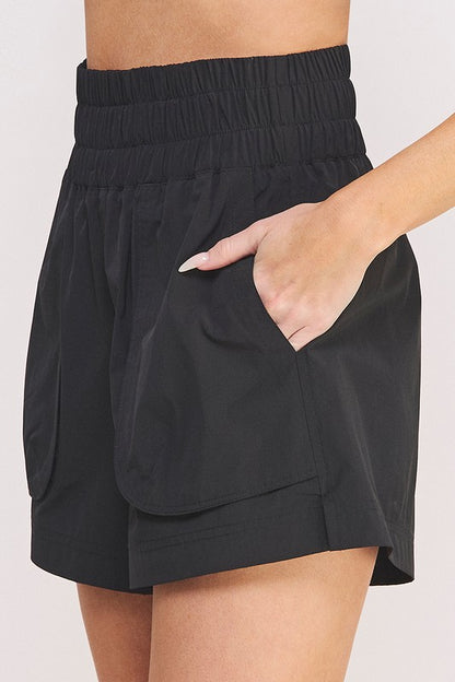 Close-up of black accordion side pocket on plus size high-waisted shorts.