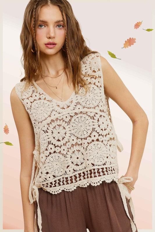 Sleeveless crochet vest with scoop neckline and side self-tie details.