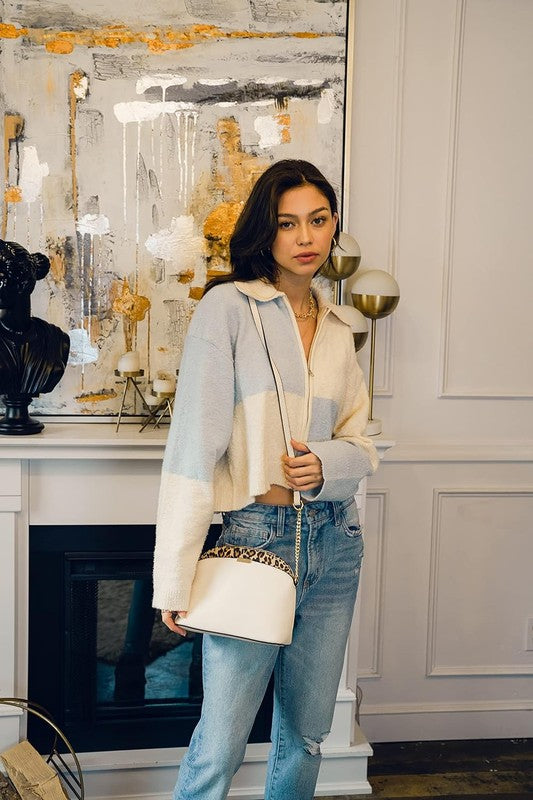 Model wearing Ivory Leopard Accent Crossbody Bag over shoulder; leopard trim and gold chain strap visible.