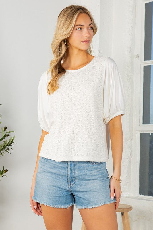 Off white lace overlay top with puff sleeves, a crew neckline, and a regular fit