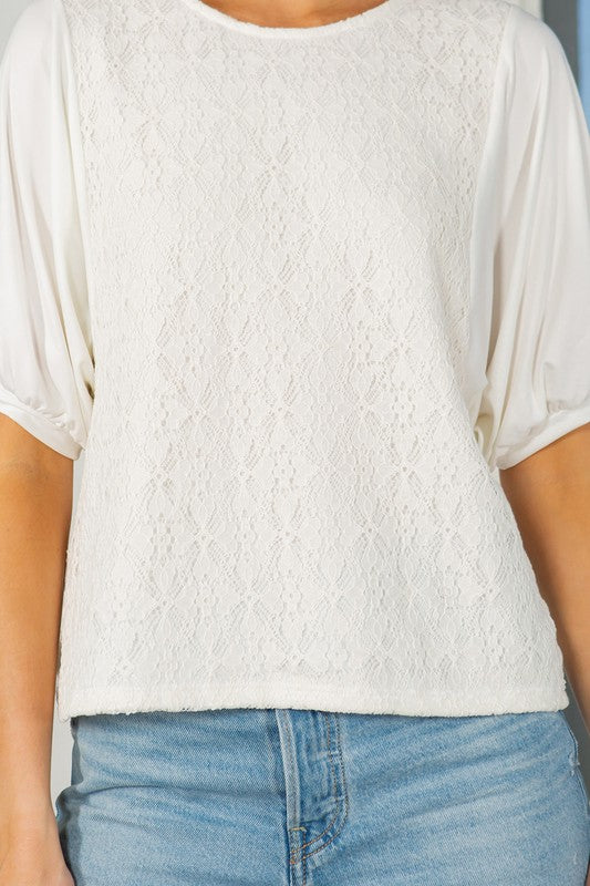 Off white lace overlay top with puff sleeves, a crew neckline, and a regular fit