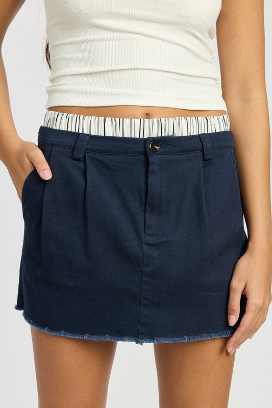 Navy mini skirt with striped double waistband, mid-rise, and a playful, retro style.