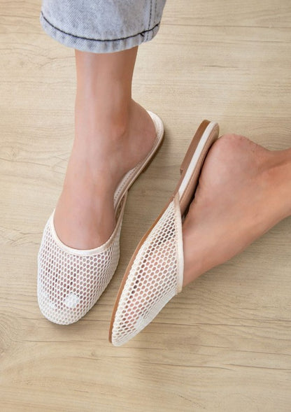 Model in champagne Levi slip-on mesh flats, flat heel, round toe, open back for casual elegance.