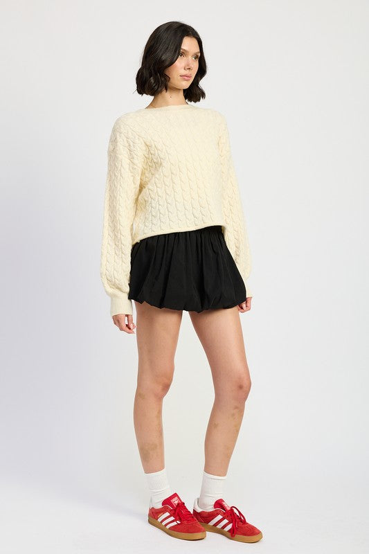 Side view of Kuuma Cable Knit Cropped Sweater showing dropped shoulders and balloon sleeves.