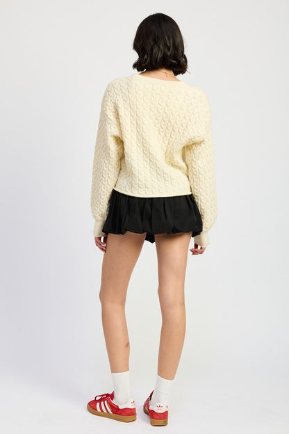 Back view of Kuuma Cable Knit Cropped Sweater in ivory with ribbed hem and relaxed fit.