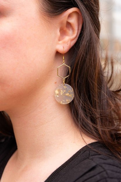 Woman wearing Layla Hexagon Acrylic Drop Earrings with gold hexagon charms and lightweight acrylic, modern geometric design. 