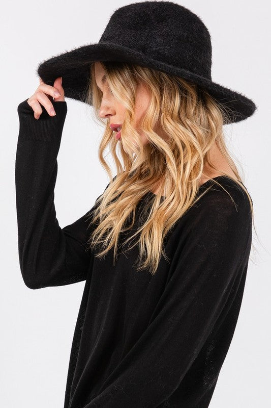 Side angle of woman wearing Halsey Fuzzy Fall Fedora Hat in Black, showing wide brim and cozy texture