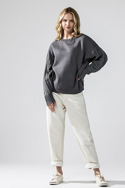 Model wearing charcoal grey Jodie sweater and light pants