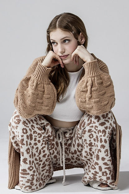 Aleah Plus Size Leopard Lounge Pants in cream with camel spots, crouched casual lifestyle pose