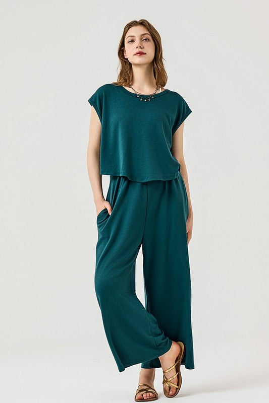 Kora Wide Leg Jumpsuit in forest green with wide-leg design and side pockets.