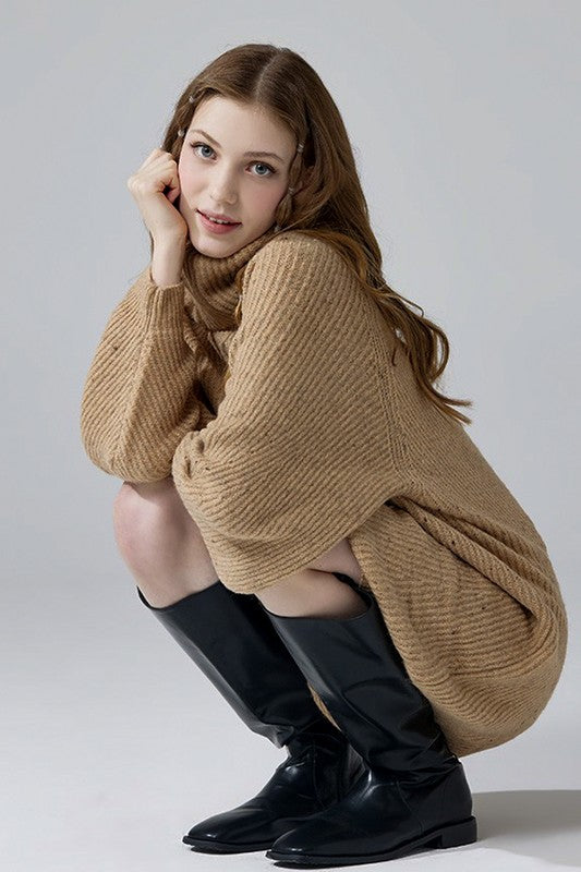 model sitting in plus size taupe confetti knit sweater dress with long sleeves.