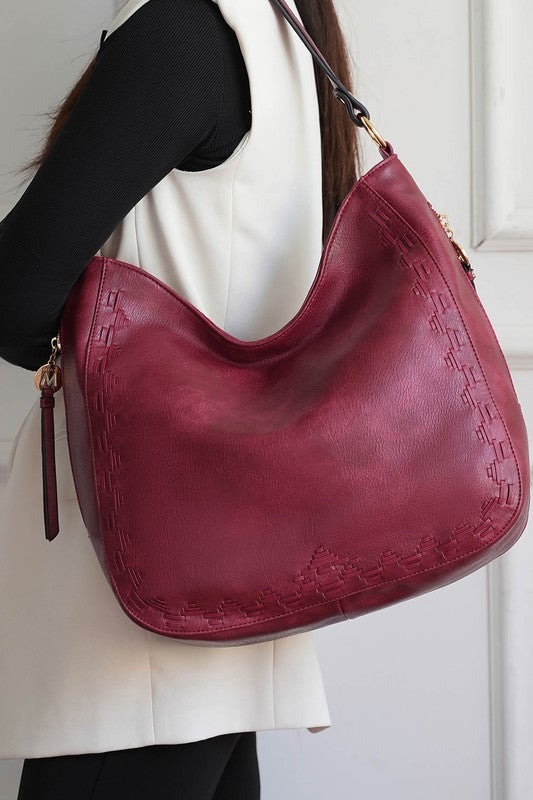 Woman wearing red MKF Lucille shoulder bag over shoulder, matching wallet in set.