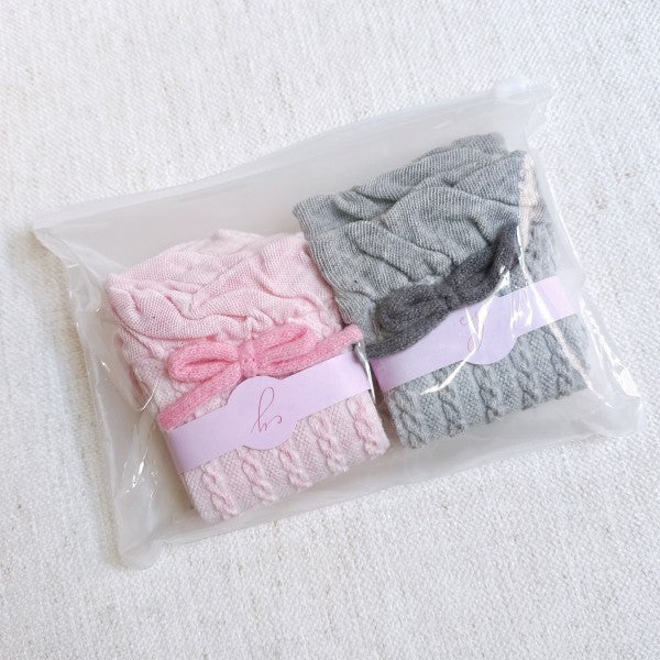 Packaged set of pink and grey Yarn Bow Socks ready for gifting.