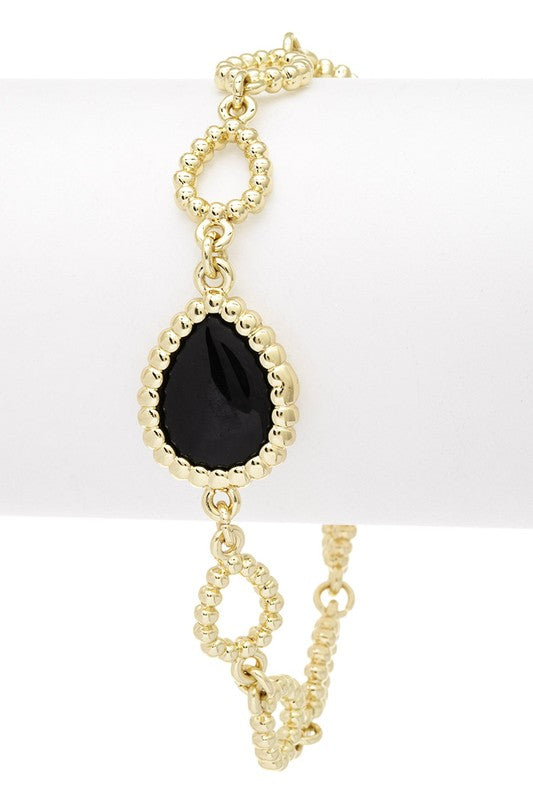 Front view of Blakely Texture Charm Link Bracelet with black center framed in 18K gold-plated links, fine jewelry design.