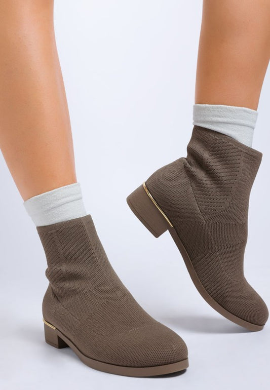 Model in taupe Rosamund Sock Boots, knitted upper with paneling detail and metallic heel rim.