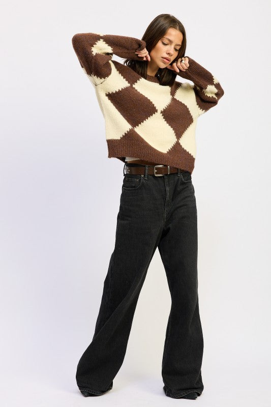Full body view model posing in Cassidy Argyle Sweater, hands raised