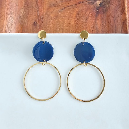 Flat lay of Sadie Earrings in navy with 18k gold-plated charm and stud posts.