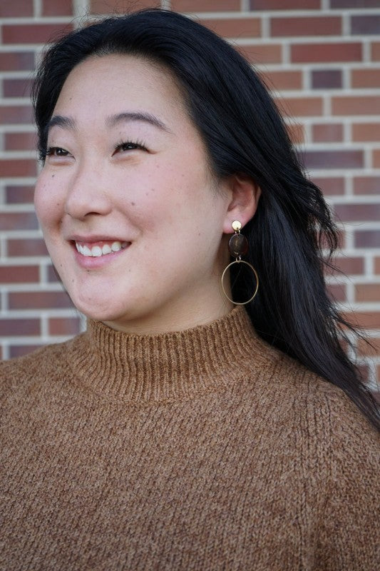 Woman wearing Sadie Earrings in Walnut showing lightweight hoop dangle and warm brown acrylic disc