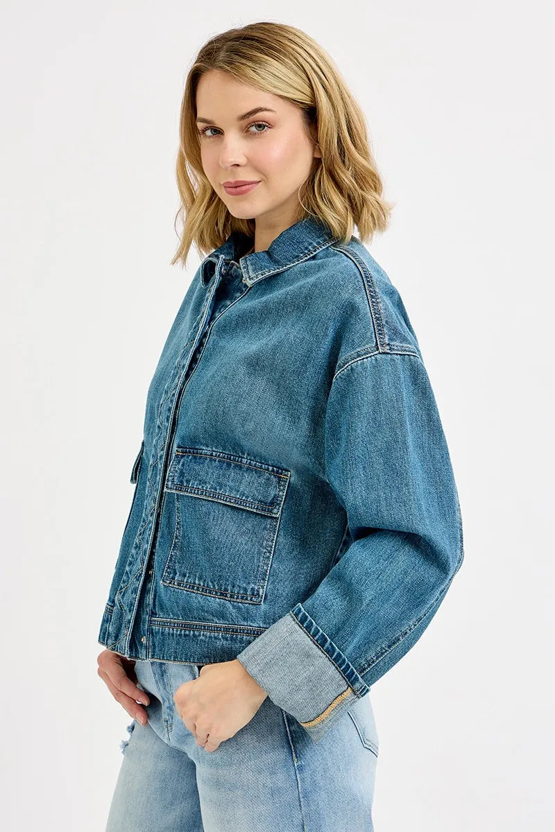 Side view showing functional flap cargo pockets and adjustable sleeve cuffs on Risen denim jacket.
