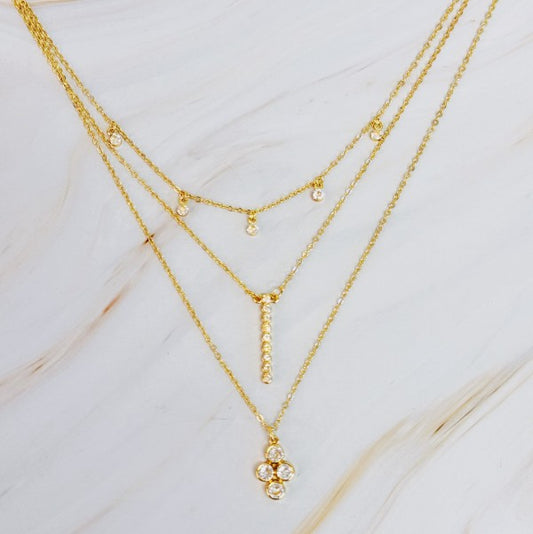 Bezel Crystals Layered Chain Necklace with three gold chains and bezel-set crystals on marble background.
