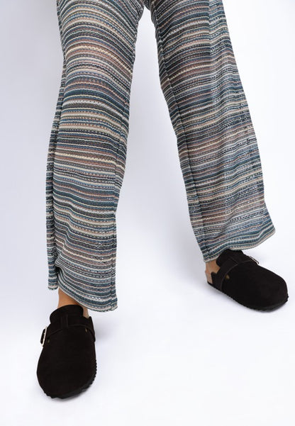 Model wearing Black Ratiha Mules front view with pointed round toe and buckle strap.