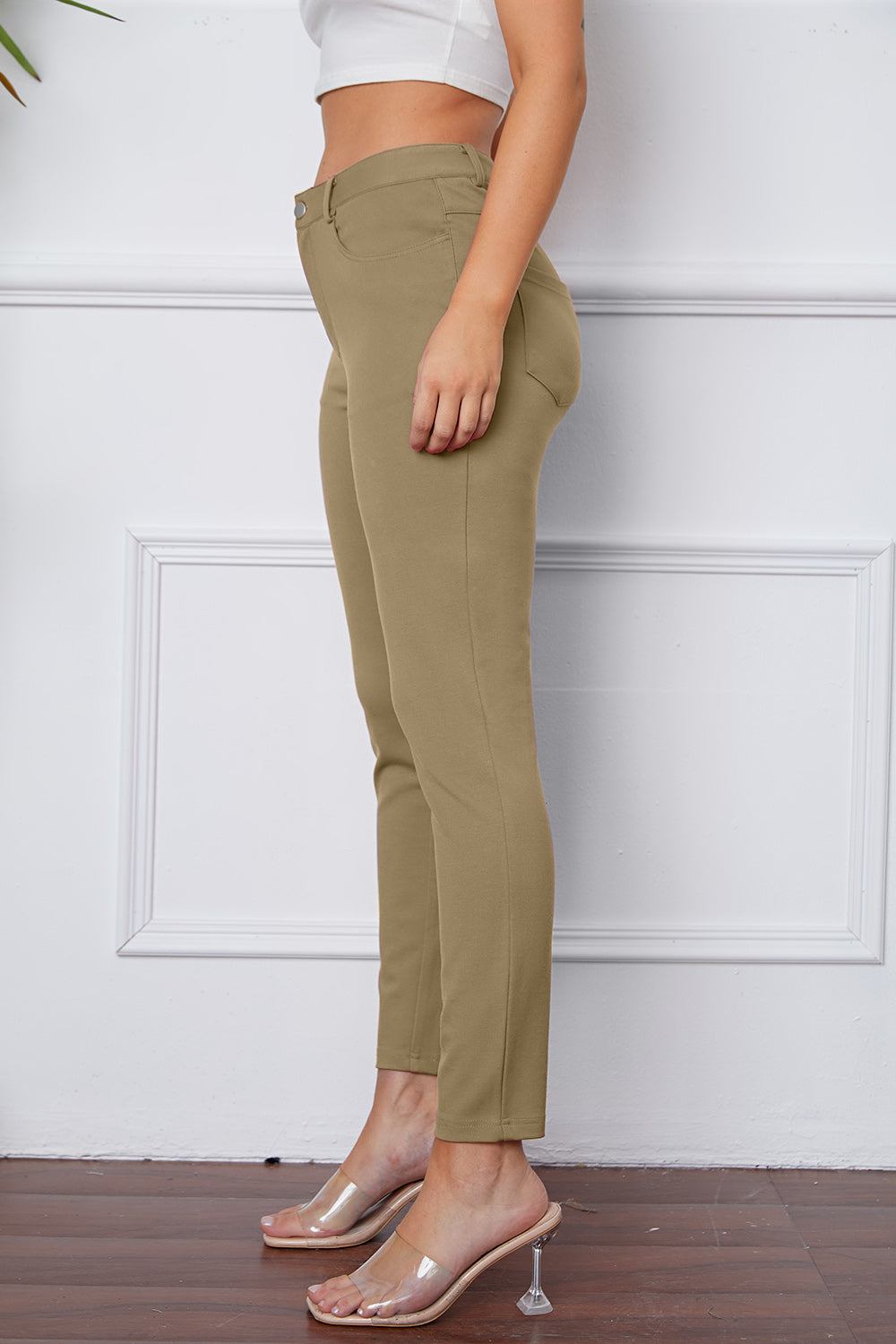 Khaki stretchy high-waisted pants feature pockets, a zip fly, and belt loops. 