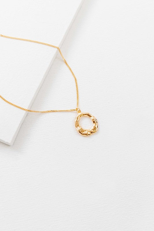 Flat lay of Charming Circle Necklace in Gold with textured pendant
