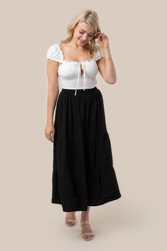 Tiered maxi skirt with elastic waistband in black. Flowy silhouett, lined for full coverage.