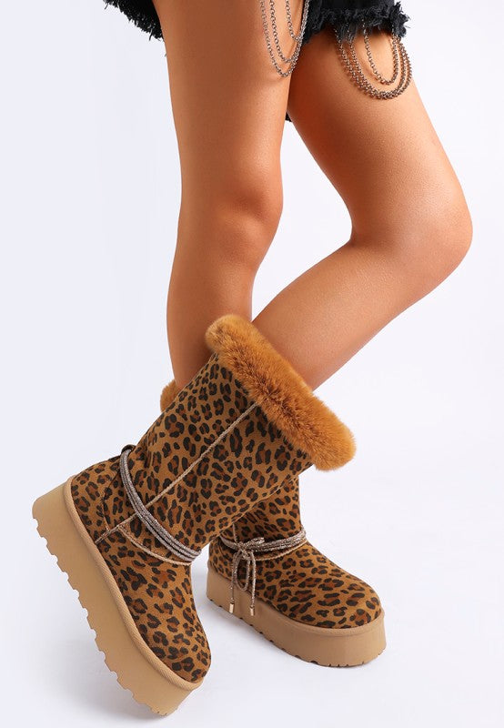 Model wearing leopard boots full view, showing bold print and fur trim.
