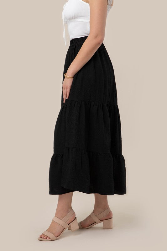 Tiered maxi skirt with elastic waistband in black. Flowy silhouett, lined for full coverage.