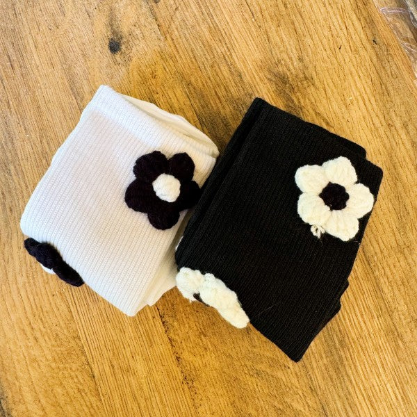 Folded black and white Puffy Daisy Socks stacked, highlighting daisy detail.
