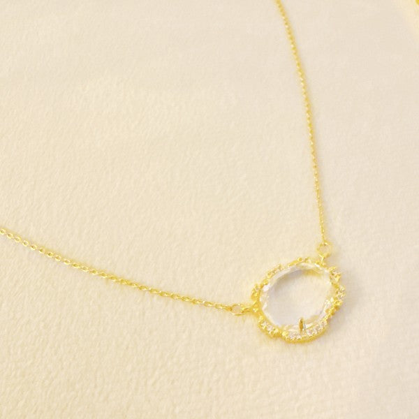 Clustered Glass Jewel Necklace with clear glass stone and gold chain, minimal flat lay.