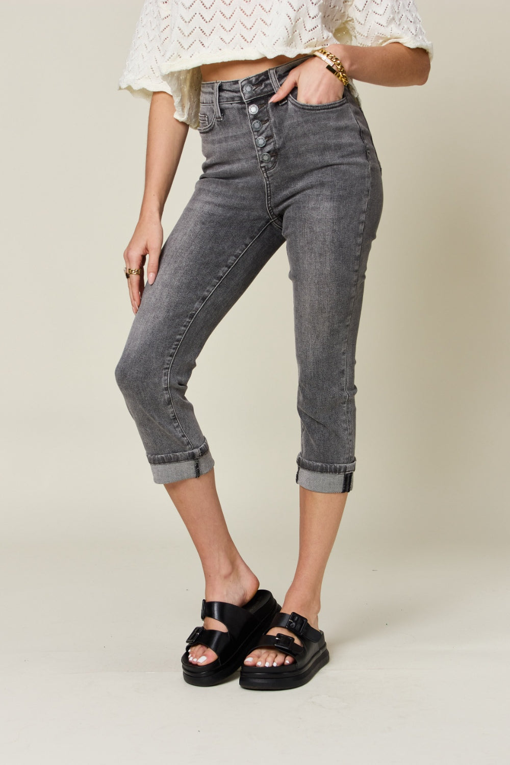 Button fly high waist cuffed capris in gray feature a high waist, button fly, and cuffed hem. Made with slightly stretchy material.