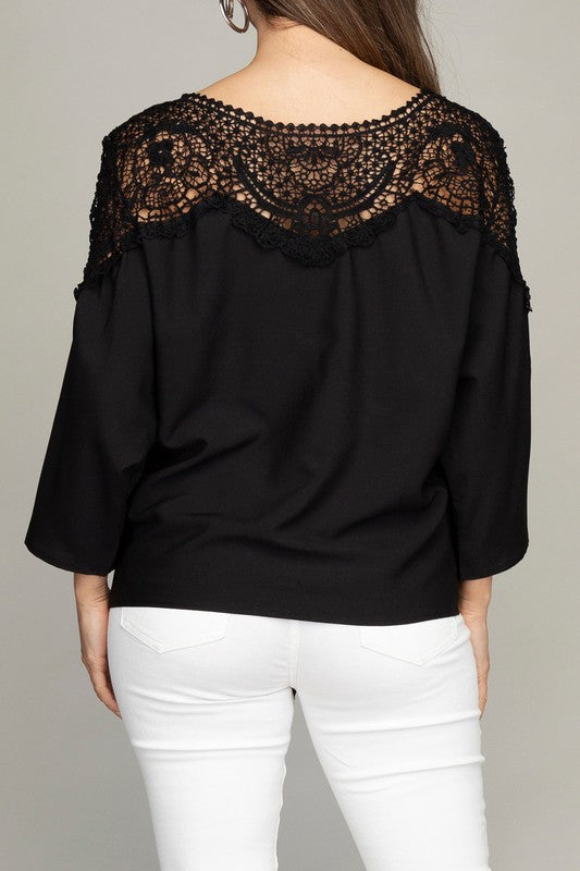 Elegant black blouse with a lace-trimmed neckline, dolman sleeves, and a charming tie.