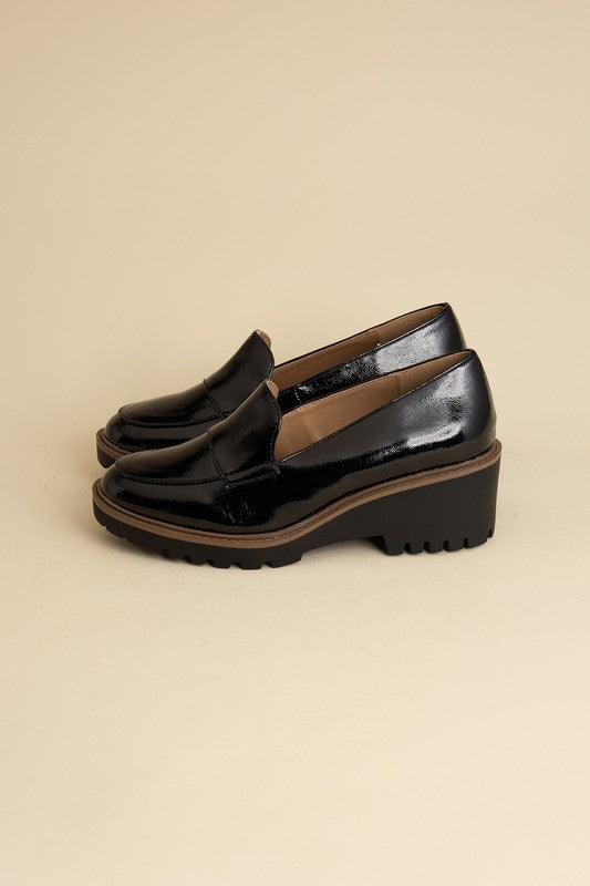 Chunky loafers in black feature a sleek design with a 2.3" heel.