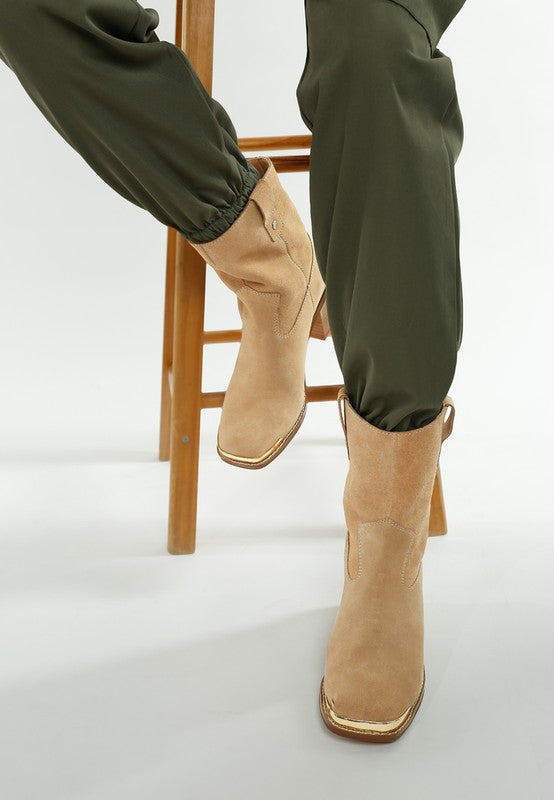 Angled shot highlighting soft suede texture and metallic detail on beige Emberly boots.