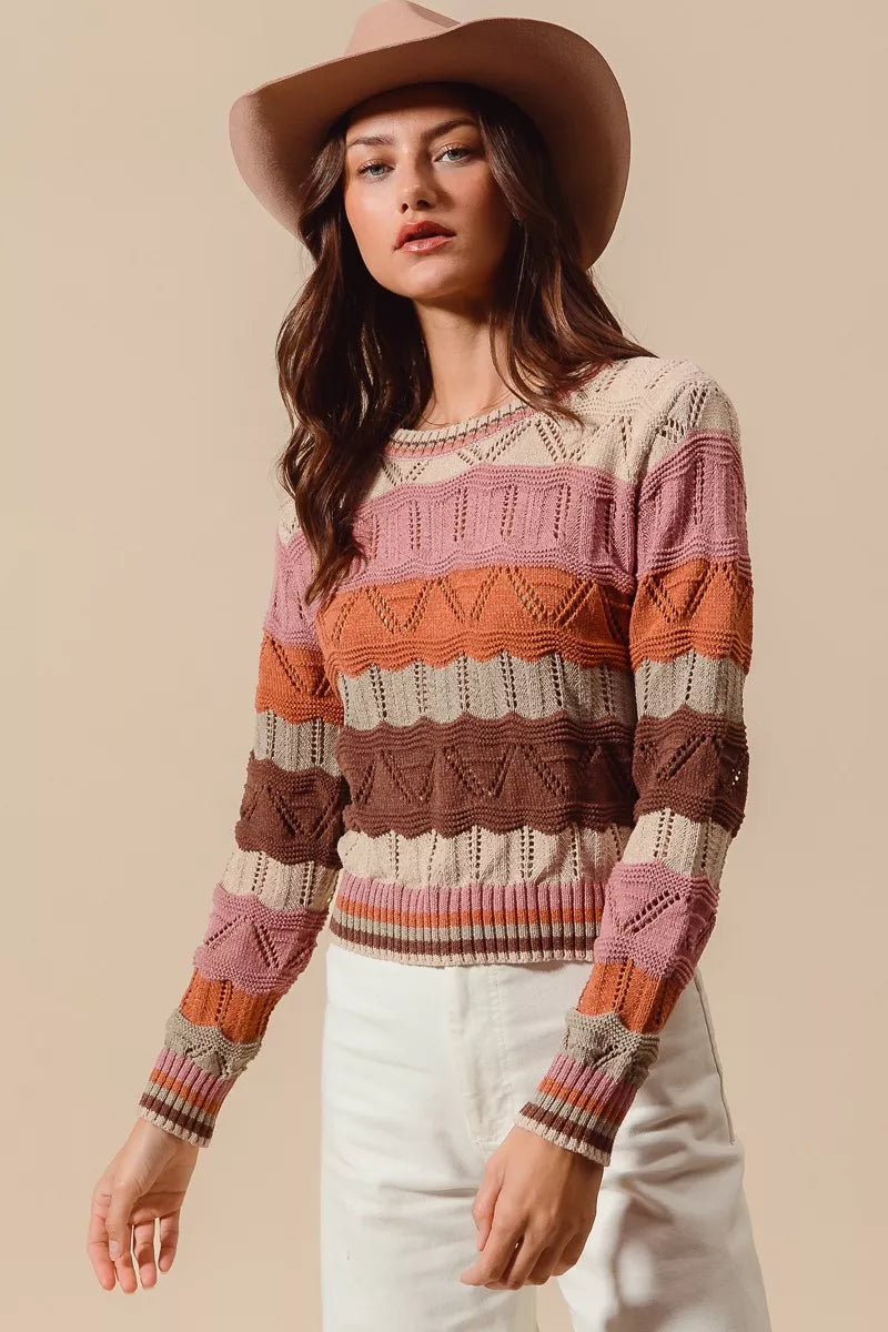 Model wearing Nina Multi Color Wavy Stripe Sweater Top in oatmeal combo tones.