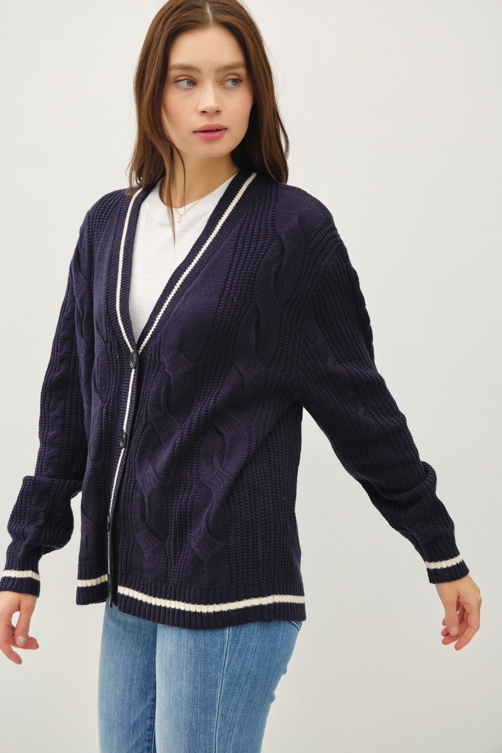 Navy and white contrast trim cable-knit cardigan with woven details and button closure.